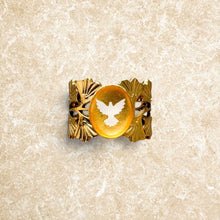 Charger l'image dans la galerie, Bague Spiritus Fleur Nabert créations en acier doré avec colombe, résine ambrée et détails de feuilles de ginkgo.
