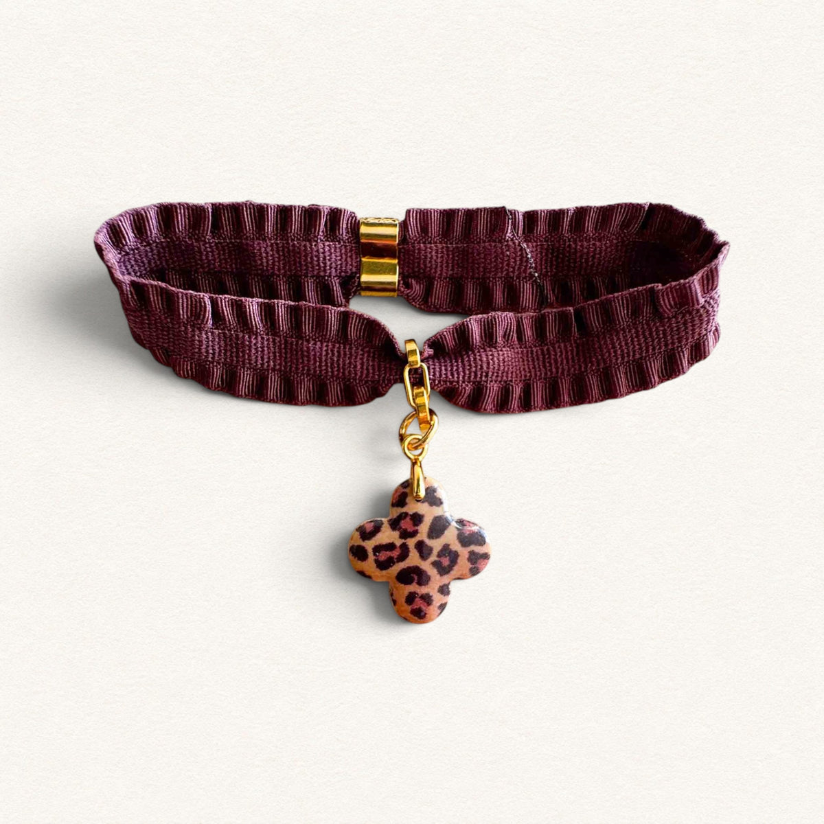 Purple Pompadour ribbon bracelet featuring a leopard-print cross, created by Fleur Nabert Creations
