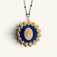 Load image into Gallery viewer, Collier Fleur Nabert créations avec médaille miraculeuse dorée, entourée d'une couronne de fleurs en résine bleue.
