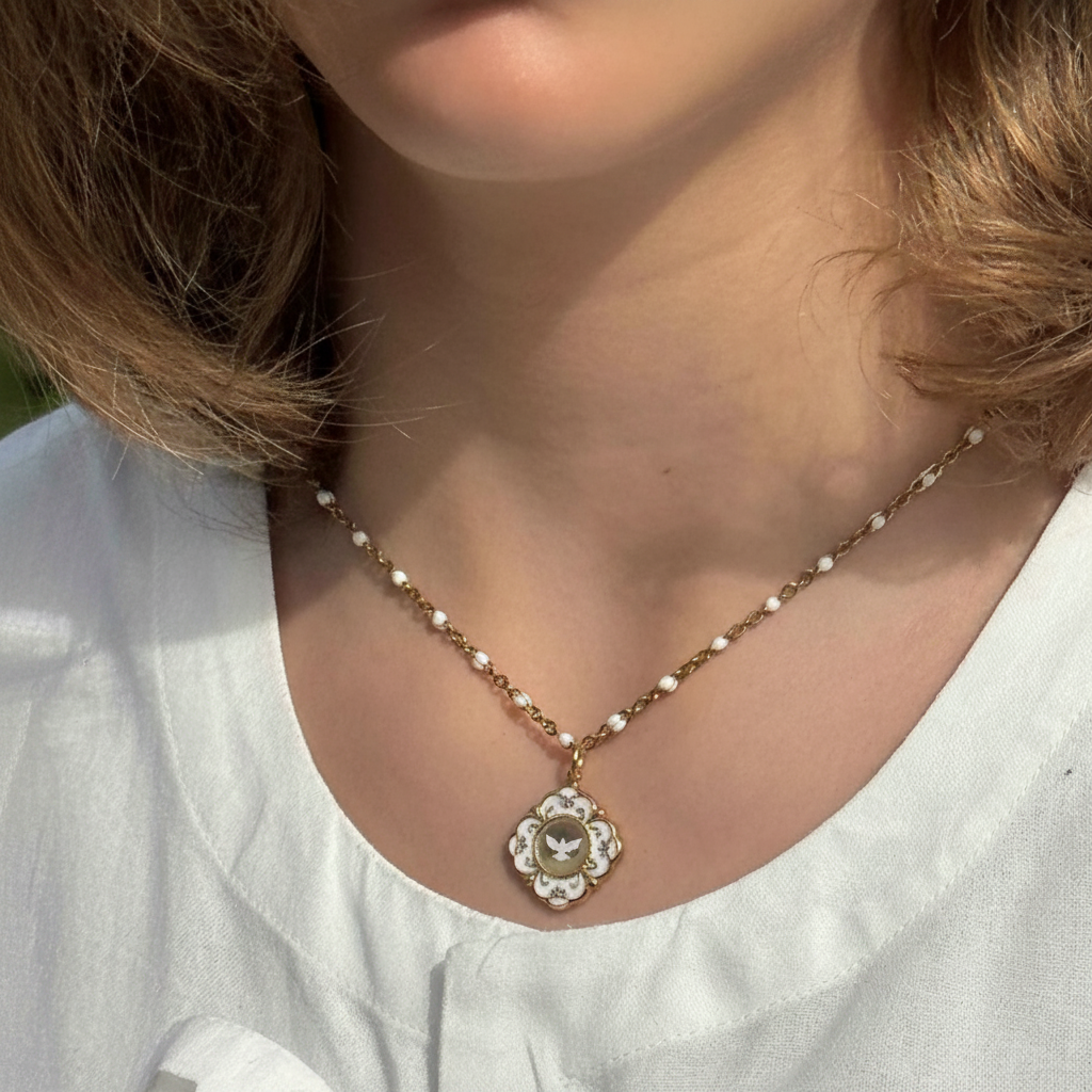 Precious white dove medal, Fleur Nabert creations, worn as a necklace with gold details and white resin