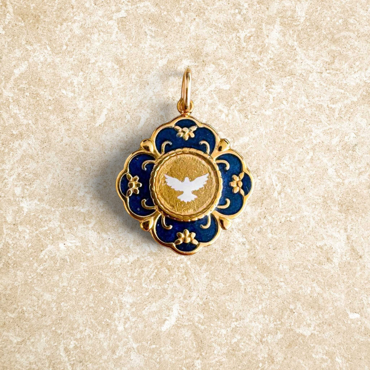 Gilded Fleur Nabert Creations medal with a white dove on a navy blue background, cloisonné style, for baptism.
