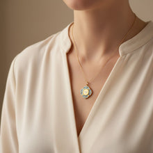 Charger l'image dans la galerie, Médaille Précieuse Colombe ciel Fleur Nabert créations en acier doré et résine bleue portée en collier
