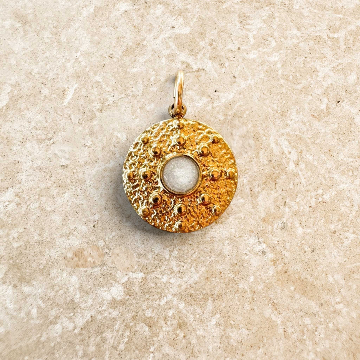Médaille dorée Fleur Nabert créations avec mica blanc nacré, design texturé inspiré d'un ostensoir pour Jeudi saint.
